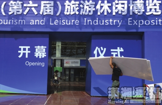 10月15日，长沙红星国际会展中心，工人搬着材料走进2015湖南(第六届)旅游休闲博览会布展现场。图/记者辜鹏博